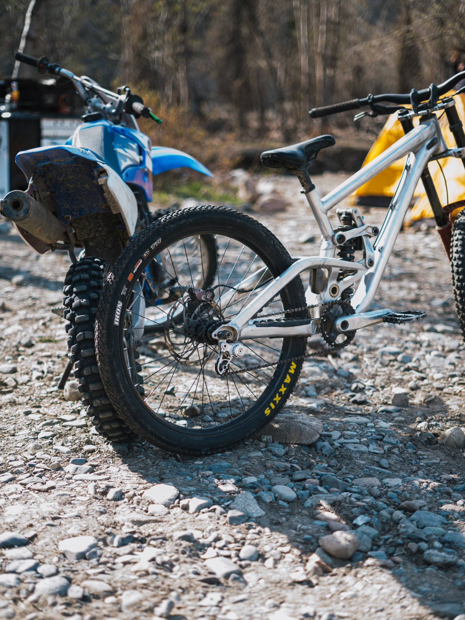 Two bicycles on a gravel path with a blurred natural background